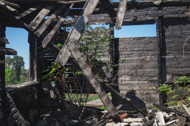 Yanık ahşap panoları ve pencere ev duvarlarının siyah kömür doku. Yıkık ev inşa bir yangından sonra. Ahşap oda içinde ev en üst kattaki bir yangından sonra duvarına.