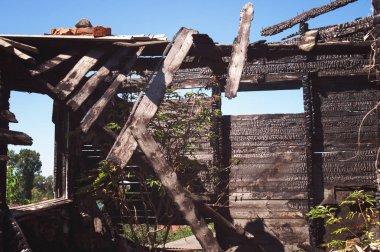 Yanık ahşap panoları ve pencere ev duvarlarının siyah kömür doku. Yıkık ev inşa bir yangından sonra. Ahşap oda içinde ev en üst kattaki bir yangından sonra duvarına.