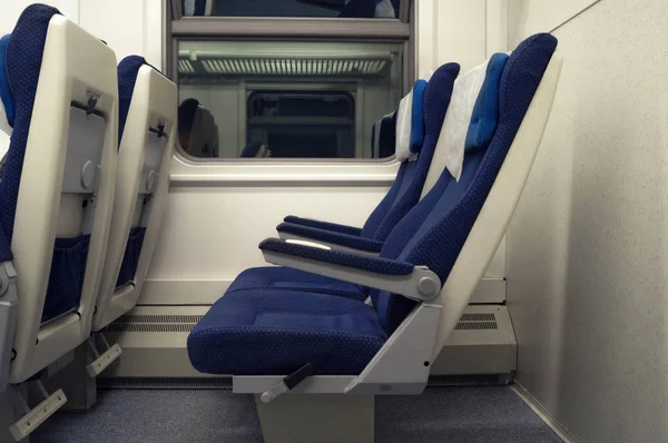 Cadeiras vazias na vista lateral do trem. O interior do vagão ferroviário, carruagem com bancos azuis — Fotografia de Stock