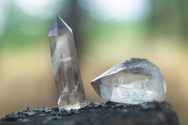 Large clear pure transparent great royal crystals of quartz chalcedony diamond brilliant on nature blurred bokeh background close up.