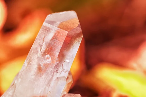 Kvartskristall på bakgrund av brasa kol och brinnande eld orange färg. Vacker pärla chalcedony — Stockfoto