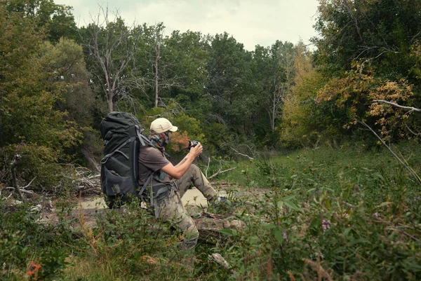 野生の初秋の写真の自然で大規模なバックパックを持つ観光客。タイガの森、沼の風景です。ハードハイキング — ストック写真