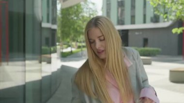 Şehir Sabah Güneşi 'nde Neşeli Dans Eden Mutlu Genç Kadın. Neşesini ve güvenini ifade eden şık kadın, doğal ışık ve pozitif enerjisiyle Parlak Şehir Caddesinde özgürce hareket ediyor.