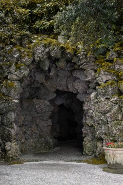 Canlı yosun ve yeşil bitkilerle kaplı bu büyüleyici taş mağaranın içinden gizli bir geçit keşfet. Kemer yolu, Como Gölü boyunca uzanan tarihi bir bahçe içindeki gizli harikalara işaret ediyor..