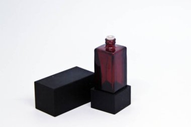 Beyaz arka planda siyah parfüm şişesi.