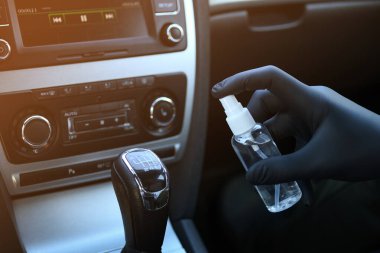 Arabanın içi bakteri ve çeşitli haşerelerden dezenfekte edilmiş. Covid 19 'dan koruma. Adam ellerini tutar ve sıvı püskürtür..