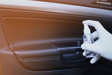 Arabanın içi bakteri ve çeşitli haşerelerden dezenfekte edilmiş. Covid 19 'dan koruma. Adam ellerini tutar ve sıvı püskürtür..