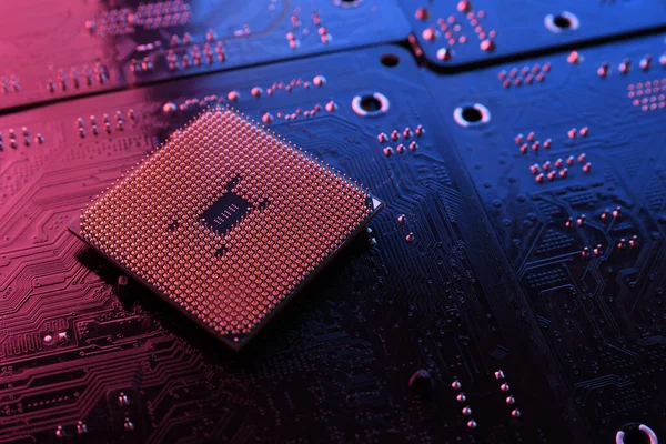 Computer cpu processor chip on circuit board ,motherboard background. Close-up. With red-blue lighting.