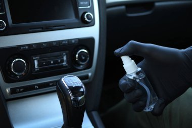 Arabanın içi bakteri ve çeşitli haşerelerden dezenfekte edilmiş. Kovid 19 'dan koruma. Adam ellerini tutar ve sıvı püskürtür..