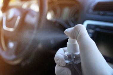 Arabanın içi bakteri ve çeşitli haşerelerden dezenfekte edilmiş. Kovid 19 'dan koruma. Adam ellerini tutar ve sıvı püskürtür..