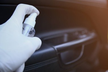 Arabanın içi bakteri ve çeşitli haşerelerden dezenfekte edilmiş. Kovid 19 'dan koruma. Adam ellerini tutar ve sıvı püskürtür..