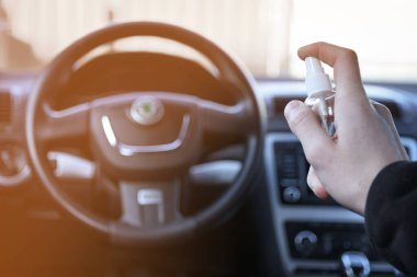 Arabanın içi bakteri ve çeşitli haşerelerden dezenfekte edilmiş. Kovid 19 'dan koruma. Adam ellerini tutar ve sıvı püskürtür..