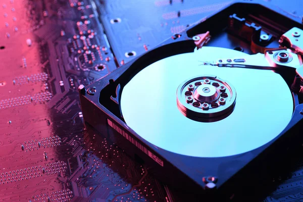 Bilgisayar sabit diski HDD, devre kartında SSD, anakart geçmişi. Yakın plan. Kırmızı-mavi ışıkla