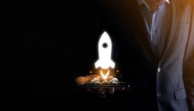 Girişim konsepti, Tablet ve simge roketi tutan İşadamı ekrandan koyu arkaplanda ağ bağlantısı ile fırlıyor ve yükseliyor.