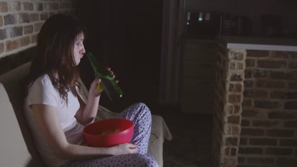 Vrouw huilen en het drinken van bier met chips — Stockvideo