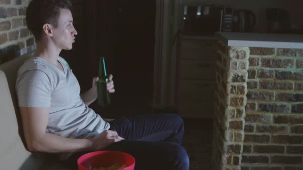 Man, voetbalfan is het drinken van bier en chips in de voorkant van de Tv — Stockvideo