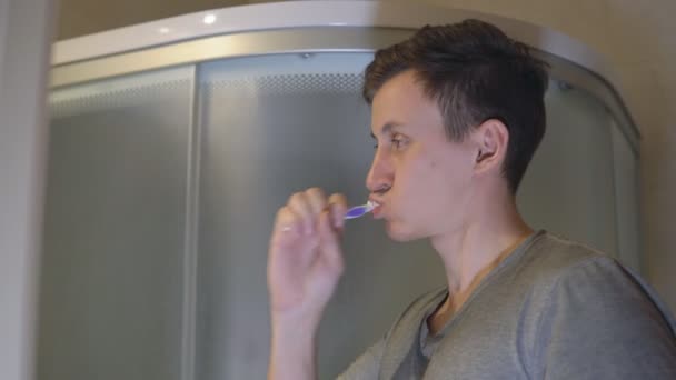 Man is brushing his teeth in the bathroom — Stock Video