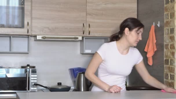 Молодая брюнетка уборщица на кухне — стоковое видео