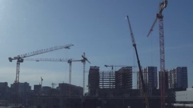 Bir açık mavi gökyüzü arka plan çeşitli inşaat vinçleri