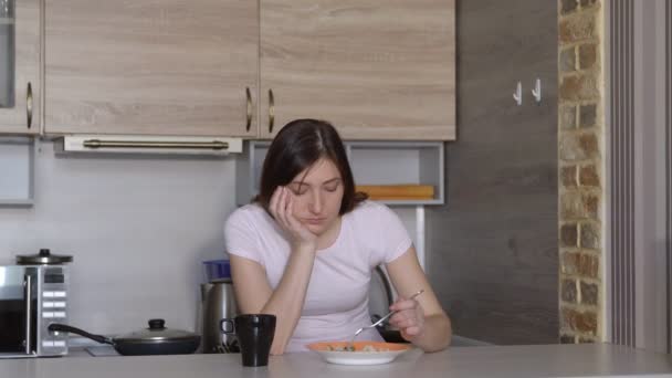 Hermosa mujer morena soñolienta desayunando en la cocina — Vídeo de stock