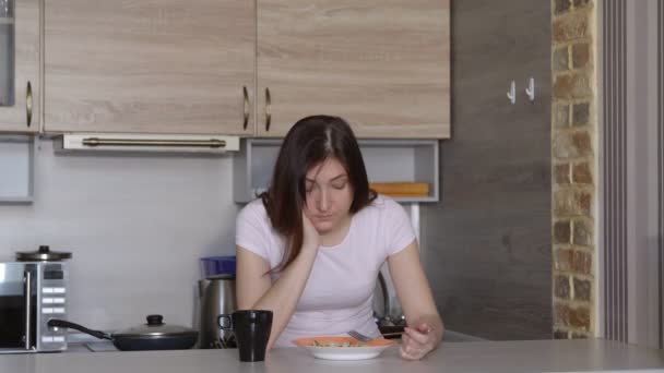 젊은 여자, 잠들 기, 부엌에 있는 테이블에서 식사 — 비디오