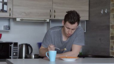 Genç yakışıklı adam yeme yulaf lapası mutfakta