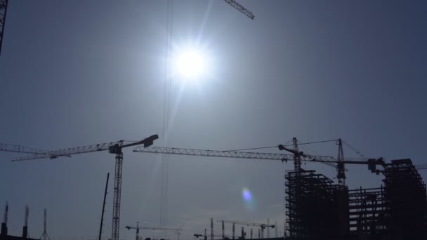 Grúas de construcción sobre el fondo del cielo soleado — Vídeo de stock