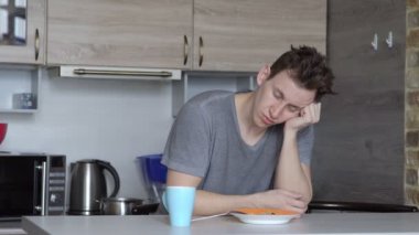 Uykulu delikanlı mutfakta kahve içme