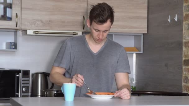 Yakışıklı genç adam mutfakta kahvaltı — Stok video