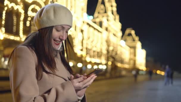 Mujer joven con abrigo no es cuadrado con el teléfono — Vídeo de stock