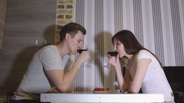Романтический вечер. Мужчина и женщина за столом пьют вино — стоковое видео