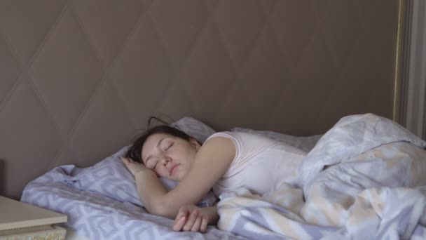 Mujer joven despierta en la cama, un sueño saludable — Vídeo de stock