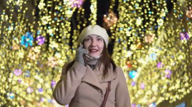 Çelenk ve telefonda konuşurken altında güzel kadın elini kolunu sallaya dönüyor