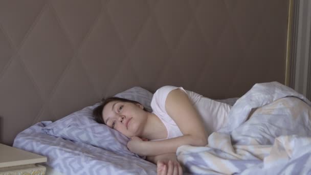 Hermosa mujer despierta en la cama, un sueño saludable — Vídeo de stock