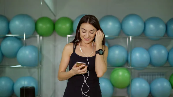 Jovem Mulher Ginásio Com Fones Ouvido Contra Fundo Bolas Ginástica — Fotografia de Stock