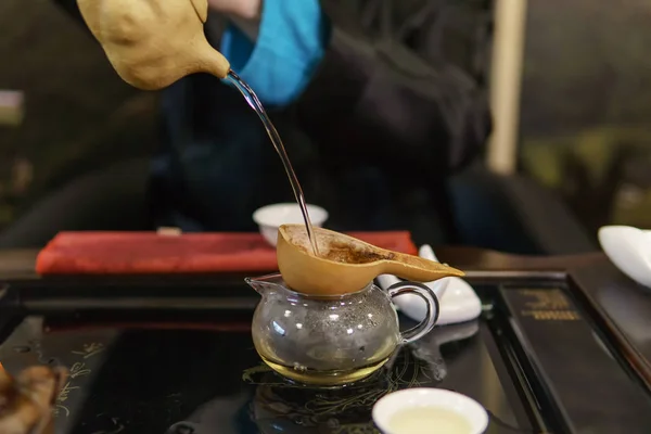 Podczas Ceremonii Parzenia Herbaty Master Wlewa Herbatę Przez Sito Zwolnionym — Zdjęcie stockowe