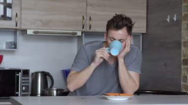 Adam, uykuya, yulaf ezmesi ve kahve mutfakta yiyor