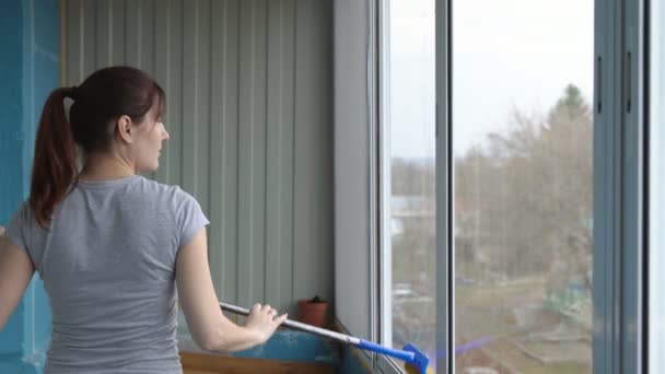 Молода жінка миє вікна з гумовим мопедом — стокове відео