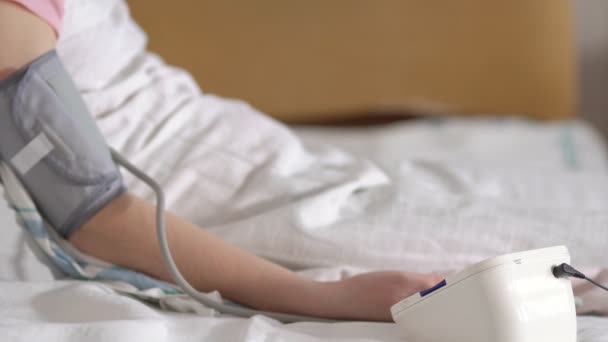 床上妇女测量电子血压计的压力 — 图库视频影像