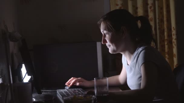 Young woman playing computer games with chips and drinks — Stock Video