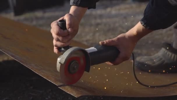 El hombre está cortando un pedazo de hierro con una sierra para metal — Vídeos de Stock