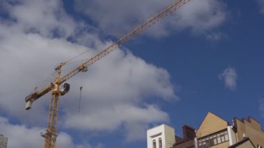 Sarı İnşaat Vinç gündüz bir bulutlu gökyüzü arka planı
