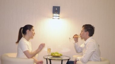 Meyve ve şampanya ile genç bir çift romantik buluşma