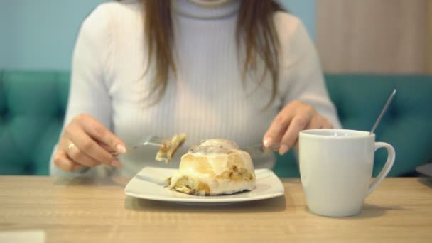 Молода брюнетка в кафе їсть десерт — стокове відео