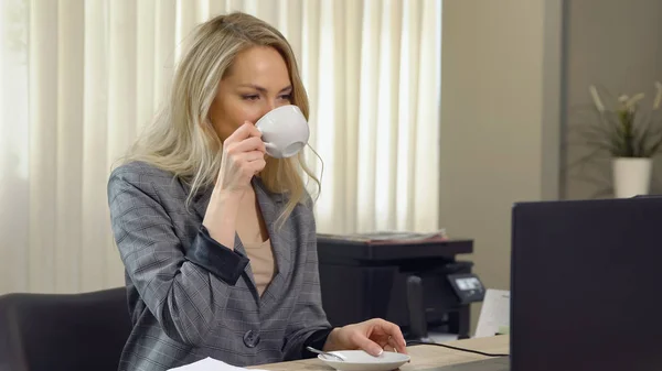 職場でコーヒー カップを取り扱いスーツの美しい女性実業家 — ストック写真