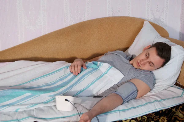 Young Man Bed Measures Pressure Electronic Tonometer — Stock Photo, Image