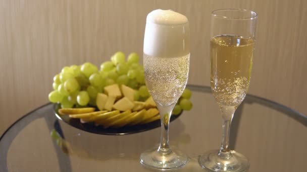 Champán en copas y un plato de fruta sobre la mesa — Vídeos de Stock
