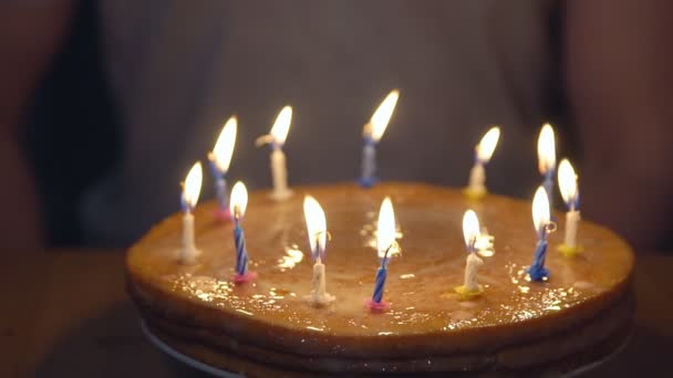 Festliche Torte mit brennenden Kerzen auf dem Hintergrund eines Mannes — Stockvideo