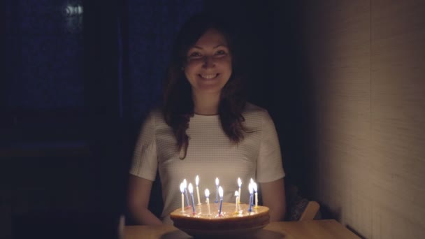 Young woman blowing out candles on holiday cake — Stock Video