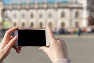 Kadın el smartphone almak fotoğraf kalabalık tutarak.